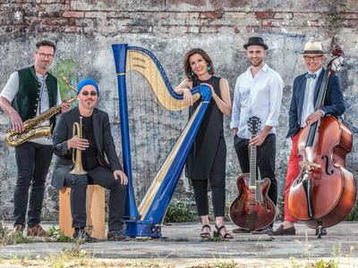 fünf Musiker aus Bayern mit ihren Instrumenten Harfe, Saxophon, Trompete, Gitarre und Kontrabass